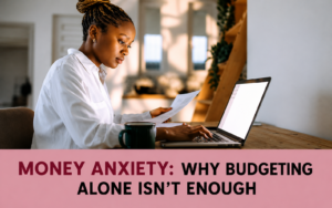 Woman reviewing financial documents beside a laptop, illustrating money anxiety and the limitations of budgeting alone.